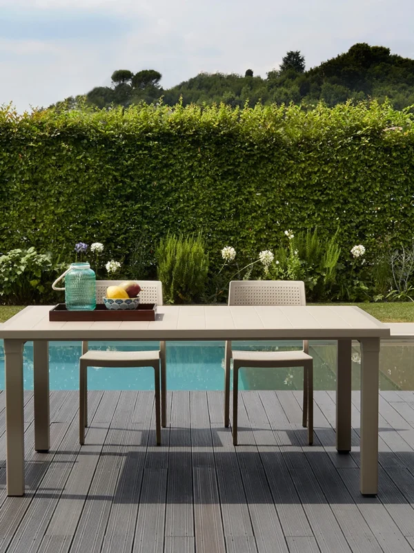 Πλαστική καρέκλα εξωτερικού χώρου Emi σε τραπεζαρία κήπου με πράσινο φόντο