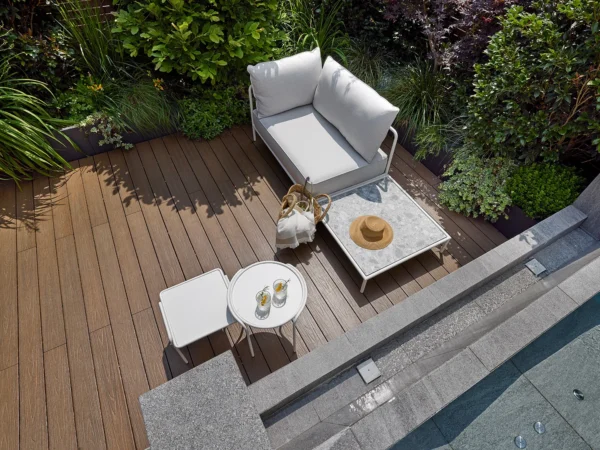 Έπιπλα κήπου εξωτερικού χώρου σε μοντέρνα βεράντα με καναπέ, τραπέζι και καρέκλες δίπλα σε πισίνα
