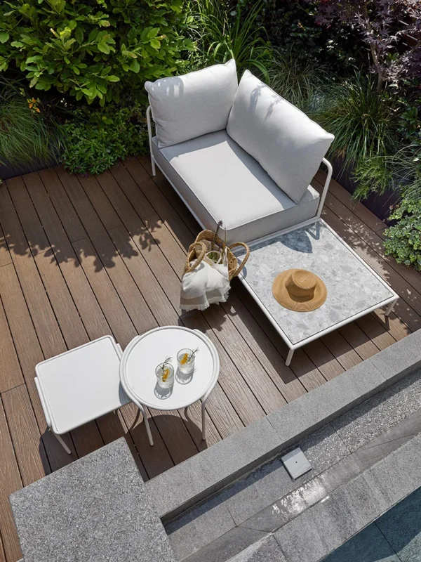 Έπιπλα κήπου εξωτερικού χώρου σε μοντέρνα βεράντα με καναπέ, τραπέζι και καρέκλες δίπλα σε πισίνα