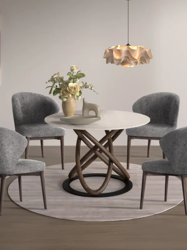 Στρογγυλή τραπεζαρία με μοντέρνα ξύλινη βάση και τέσσερις γκρι υφασμάτινες καρέκλες σε σύγχρονο χώρο