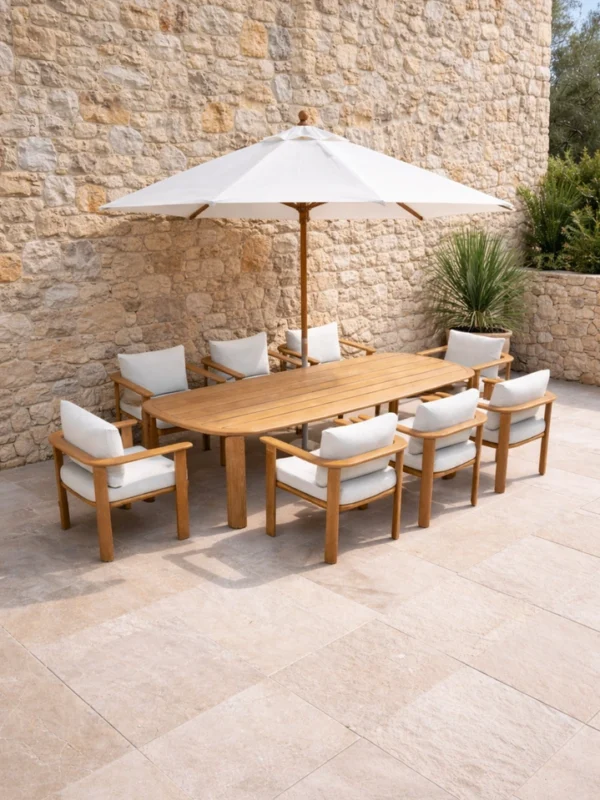 Ξύλινο outdoor τραπέζι teak με 8 πολυθρόνες και λευκή ομπρέλα σε αυλή βίλας με πέτρινο τοίχο